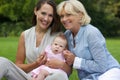 Happy mother and child sitting outdoors with grandmother Royalty Free Stock Photo