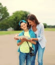 Happy mother with child son tourists sightseeing city with paper map Royalty Free Stock Photo