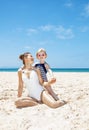 Happy mother and child in swimsuits at sandy beach on sunny day Royalty Free Stock Photo