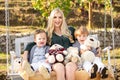 Happy mother and child swinging outdoor. Young mother with little kid son sitting on swing in summer park. Mothers day Royalty Free Stock Photo