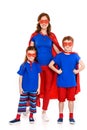 happy mother with cute little kids in superhero costumes standing together and smiling at camera Royalty Free Stock Photo