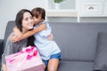 happy of mother and daughter asian with gift with pink ribbon and daughter kiss mother.