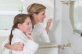 Happy mother and daughter brushing teeth together Royalty Free Stock Photo