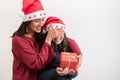 Happy mother and daughter celebrating christmas. Woman covering eyes and giving present to her little girl on white background Royalty Free Stock Photo