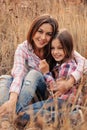 Happy mother and daughter on cozy walk on sunny field