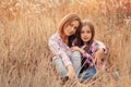 Happy mother and daughter on cozy walk on sunny field