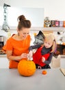 Happy mother with daughter creating Jack-O-Lantern on Halloween Royalty Free Stock Photo