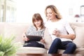 Happy mother and daughter with digital tablet