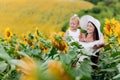 Happy mother with the daughter in the field with sunflowers. mom and baby girl having fun outdoors. family concept Royalty Free Stock Photo