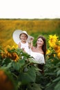 Happy mother with the daughter in the field with sunflowers. mom and baby girl having fun outdoors. family concept Royalty Free Stock Photo