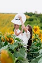 Happy mother with the daughter in the field with sunflowers. mom and baby girl having fun outdoors. family concept Royalty Free Stock Photo