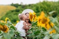 Happy mother with the daughter in the field with sunflowers. mom and baby girl having fun outdoors. family concept. selective Royalty Free Stock Photo