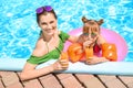 Happy mother and daughter with glasses of juice resting in swimming pool Royalty Free Stock Photo