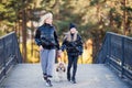 Happy mother and daughter having fun together with theirs dog. Fashionable mother and schoolgirl walking with pet in park. Autumn Royalty Free Stock Photo