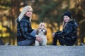 Happy mother and daughter having fun together with theirs dog. Fashionable mother and schoolgirl walking with pet in park. Autumn Royalty Free Stock Photo