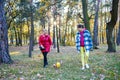 Happy mother and daughter having fun together with theirs dogin autumn park. Royalty Free Stock Photo