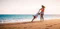 Happy mother and daughter having fun on tropical beach at sunset - Family playing next sea during summer vacation Royalty Free Stock Photo