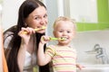 Happy mother and daughter kid girl brushing teeth Royalty Free Stock Photo