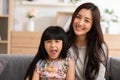 Happy mother and daughter looking at camera sending smile and cheerful face together. Funny happy mom and little girl having fun Royalty Free Stock Photo