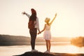 Happy mother and daughter looking at the sky during sunset Royalty Free Stock Photo