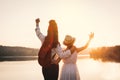 Happy mother and daughter looking at the sky during sunset