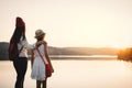 Happy mother and daughter looking at the sky during sunset