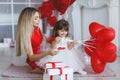 Happy mother and daughter parses gifts on Valentine`s Day Royalty Free Stock Photo