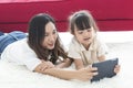 Happy mother and daughter playing together in bedroom taking a selfie. Royalty Free Stock Photo