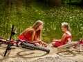 Happy mother with daughter rides bicycle and sitting on beach. Royalty Free Stock Photo