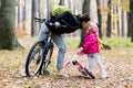 Happy mother and daughter riding bicycles in autumn park. Royalty Free Stock Photo