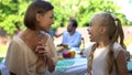 Happy mother and daughter sharing secrets on backyard of cottage, girls talks Royalty Free Stock Photo