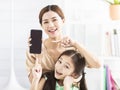 Happy mother and daughter showing the mobile phone