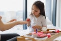 Happy mother and daughter sitting in bed at home and doing manicure. Royalty Free Stock Photo