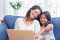 Happy mother and daughter sitting on the couch and using laptop Royalty Free Stock Photo