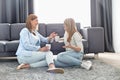 Happy mother and daughter talking while having coffee in living room Royalty Free Stock Photo