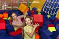 Happy mother and daughter throwing soft cubes at each other at kids entertainment centre, indoors