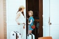 Happy mother and daughter travellers in hats opening door Royalty Free Stock Photo