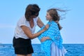 Happy mother and daughter walking together along sea beach, mom cares for her kid Royalty Free Stock Photo