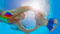 Happy mother dive underwater with little child in swimming pool Royalty Free Stock Photo