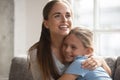 Happy mother embracing little daughter family sit on couch Royalty Free Stock Photo