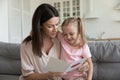 Happy mother embracing little daughter, reading greeting card Royalty Free Stock Photo