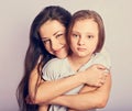 Happy mother and excited joying kid girl hugging with emotional smiling faces on purple background with empty copy space Royalty Free Stock Photo