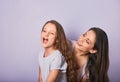 Happy mother and excited joying kid girl hugging with emotional smiling faces on purple background Royalty Free Stock Photo