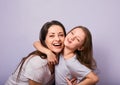 Happy mother and excited joying kid girl hugging with emotional smiling faces on purple background with empty copy space Royalty Free Stock Photo