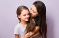 Happy mother and excited joying kid girl hugging with emotional smiling faces on purple background with empty copy space Royalty Free Stock Photo