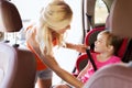 Happy mother fastening child with car seat belt Royalty Free Stock Photo