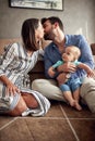 Happy mother and father holding their baby boy and kissing at ho Royalty Free Stock Photo