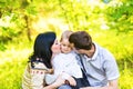 Happy mother and father kissing his little son in park Royalty Free Stock Photo