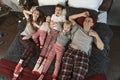 Happy mother father and three children wear pajamas and lie on large bed. Top view. Christmas or New Year Morning. Holidays Royalty Free Stock Photo