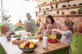 Happy mother and father with two kids baking together, standing at wooden countertop in modern kitchen, young parents Royalty Free Stock Photo